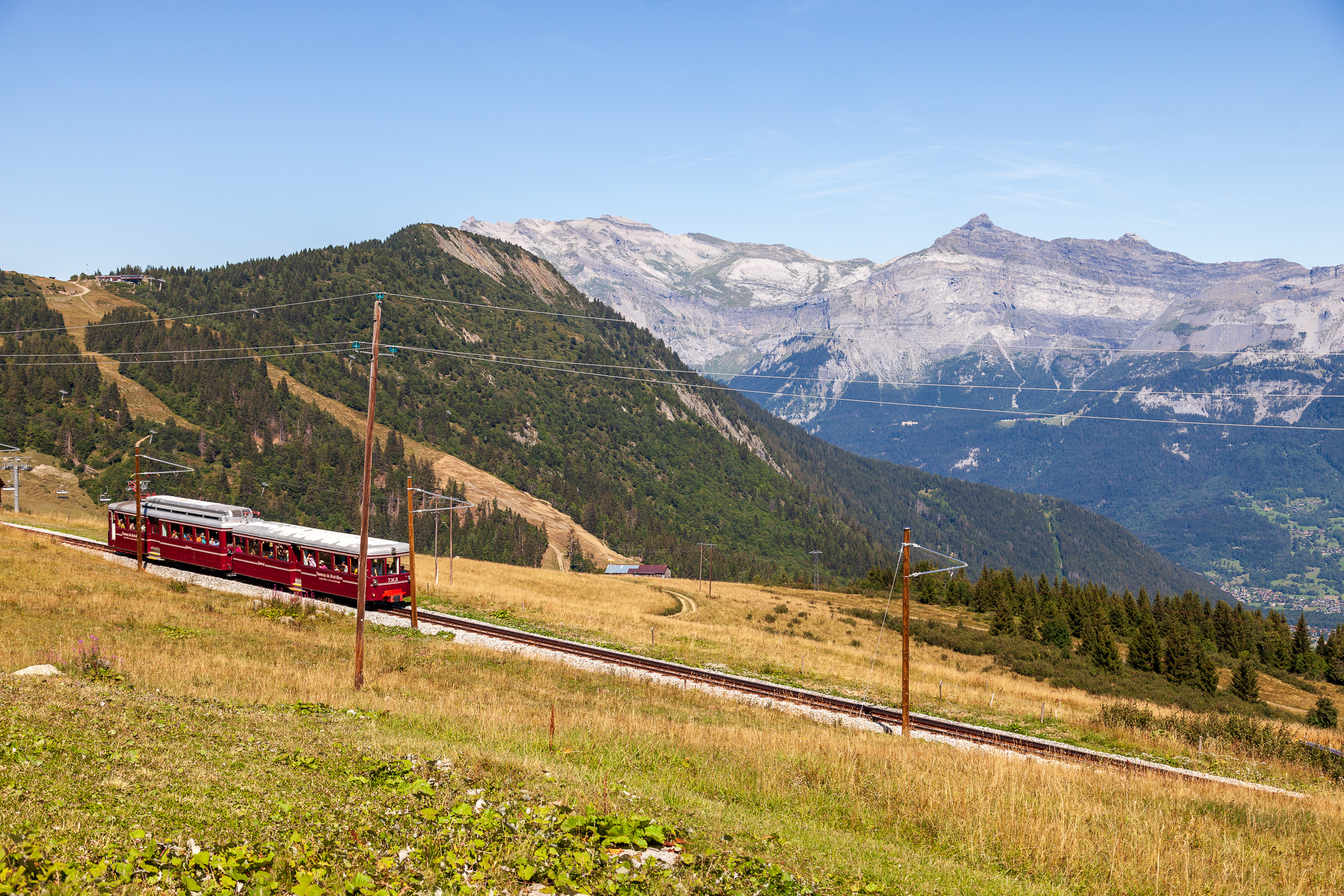 Туристы из окон трамвая весело машут трекерам